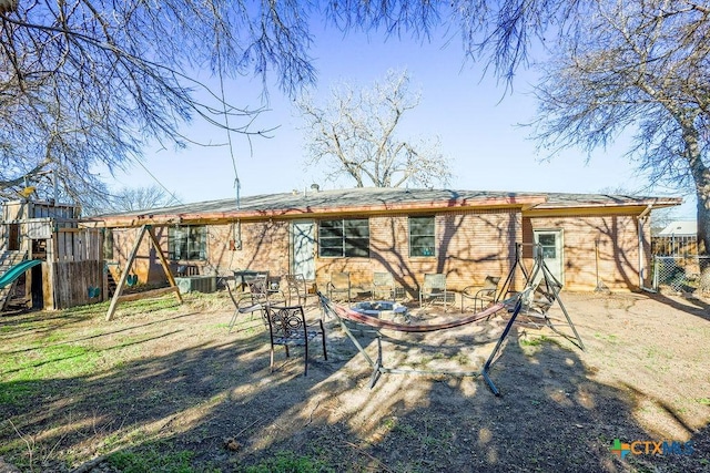 back of property featuring a playground and central air condition unit