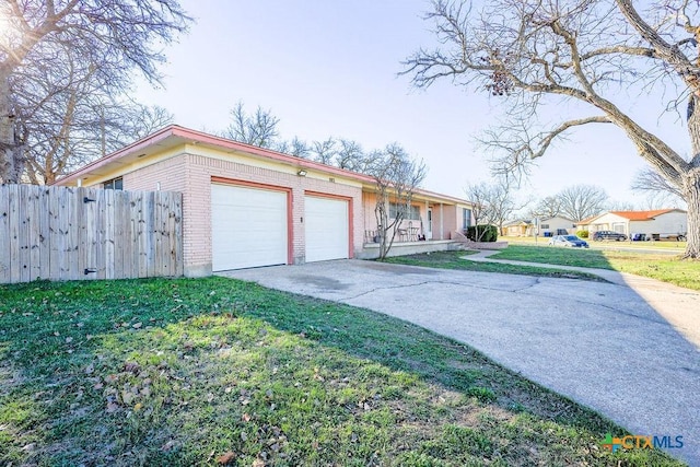 ranch-style house featuring a garage and a front lawn