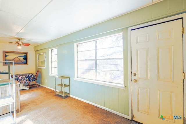 carpeted foyer entrance featuring ceiling fan