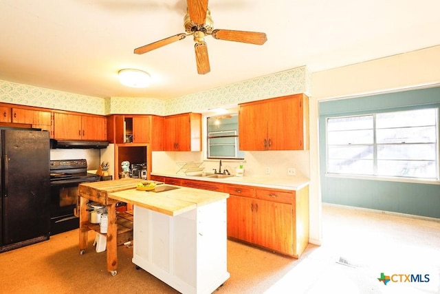 kitchen featuring a center island, black appliances, sink, ceiling fan, and butcher block countertops