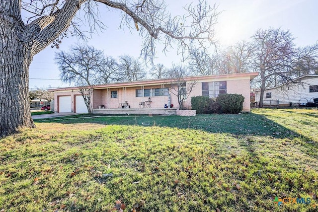 ranch-style house featuring a garage and a front lawn