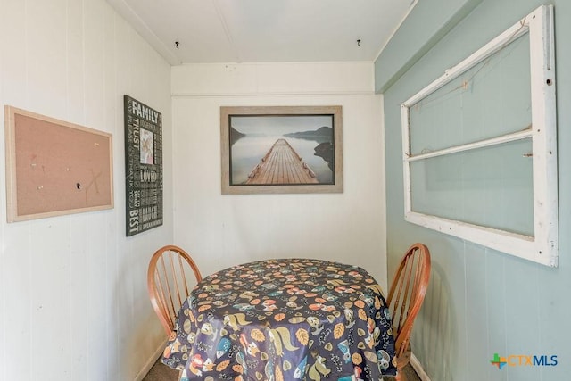 dining area featuring wood walls