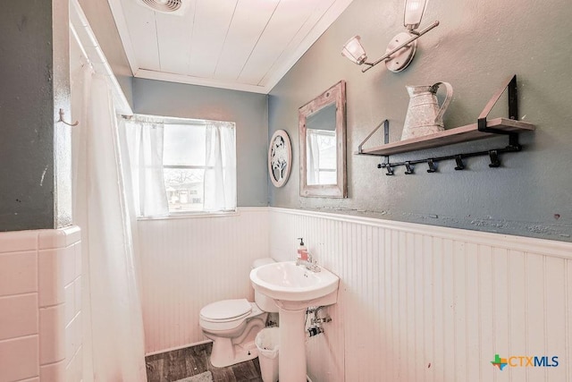 bathroom featuring crown molding, wood-type flooring, and toilet