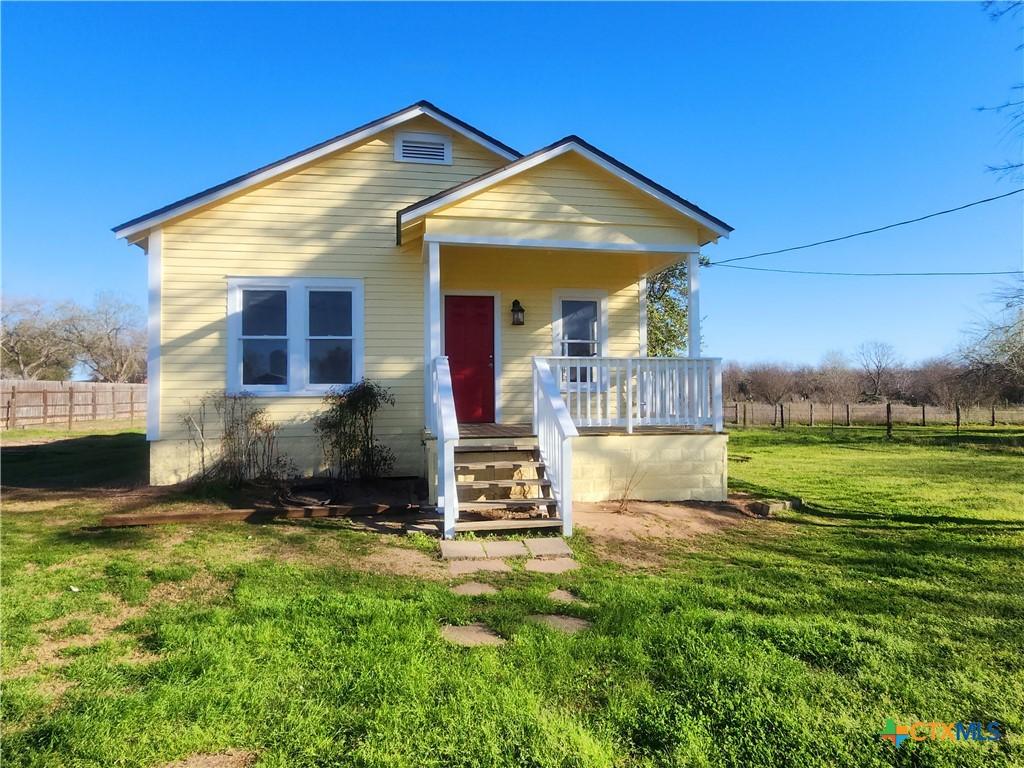 bungalow with fence and a front lawn