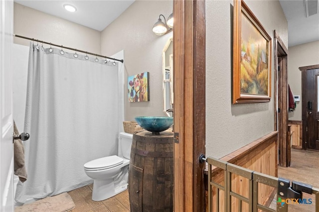 full bathroom with a shower with shower curtain, toilet, wood finished floors, and vanity