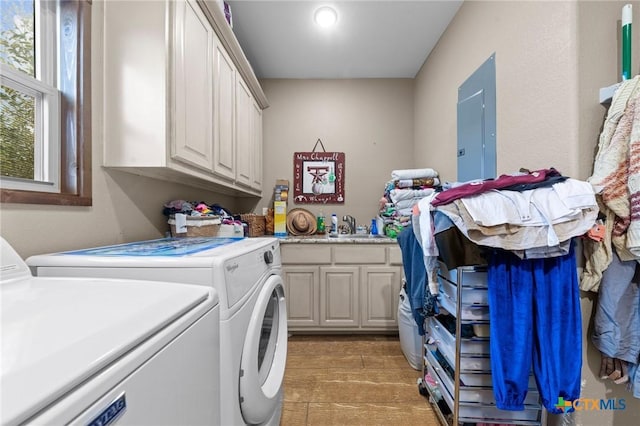 washroom with electric panel, cabinet space, independent washer and dryer, and a sink