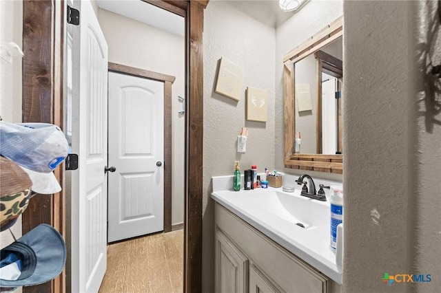 bathroom featuring vanity and a textured wall