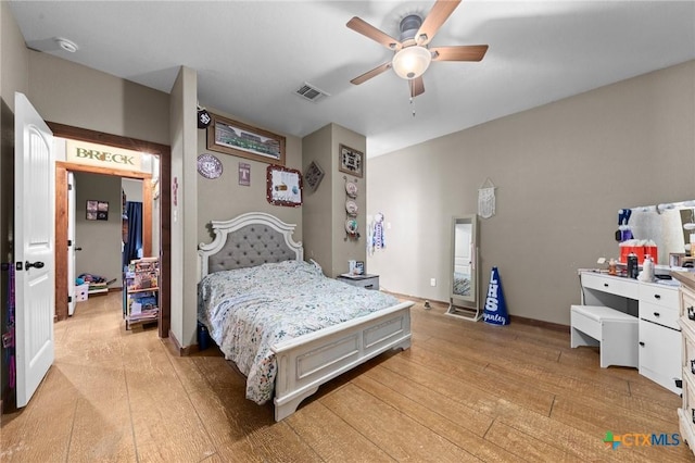 bedroom with light wood-type flooring, baseboards, visible vents, and ceiling fan