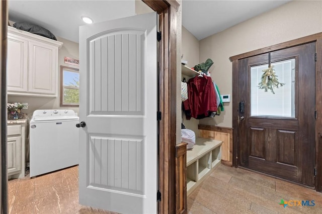 laundry area featuring washer / clothes dryer, cabinet space, and a wainscoted wall