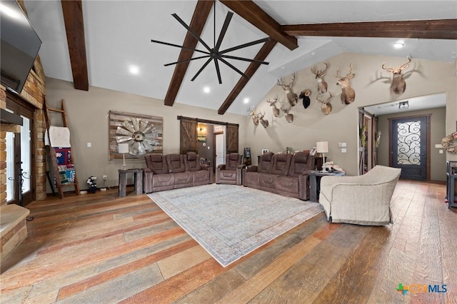 living room featuring beam ceiling, high vaulted ceiling, a barn door, and hardwood / wood-style flooring