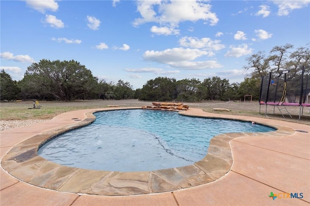 pool featuring a patio and a trampoline