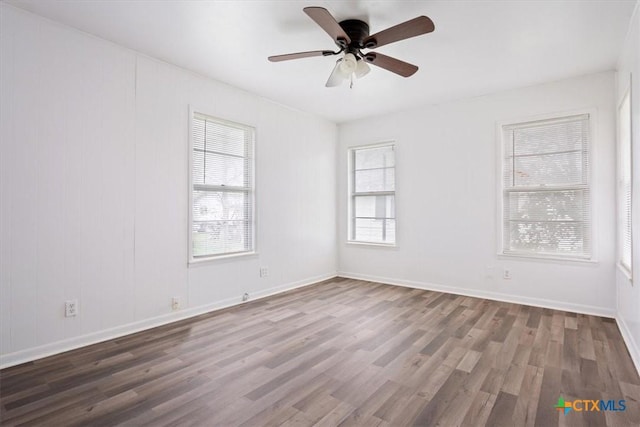 empty room with ceiling fan and dark hardwood / wood-style flooring