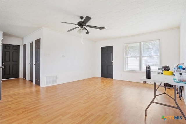 interior space featuring ceiling fan, light wood-type flooring, and crown molding