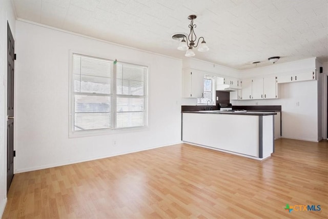 kitchen with decorative light fixtures, white cabinets, kitchen peninsula, light hardwood / wood-style flooring, and crown molding