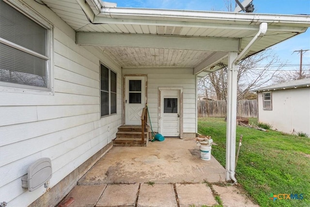 entrance to property with a patio and a lawn