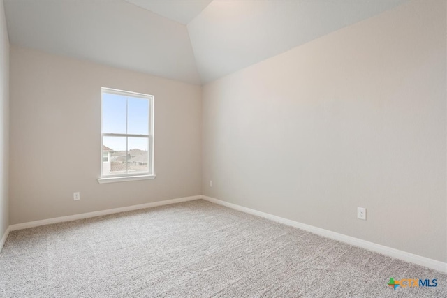 empty room with lofted ceiling and carpet