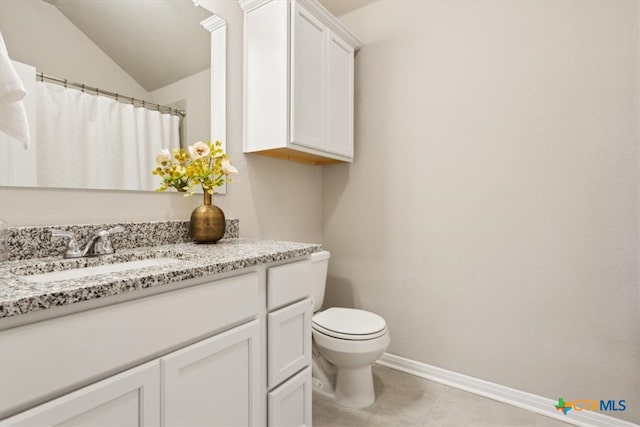 bathroom featuring toilet, vanity, lofted ceiling, and tile patterned floors