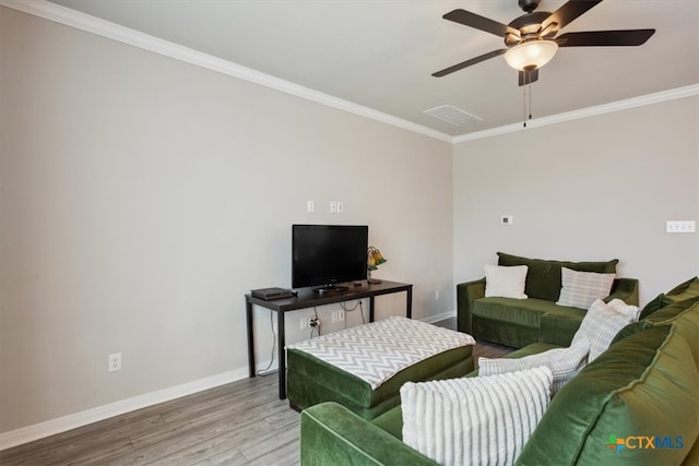 living room with hardwood / wood-style floors, ceiling fan, and crown molding