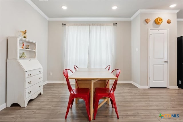 dining area featuring light hardwood / wood-style floors and crown molding