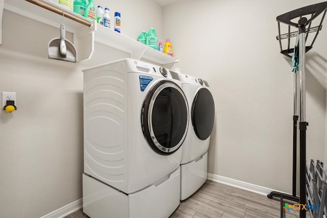 clothes washing area with light hardwood / wood-style floors and separate washer and dryer