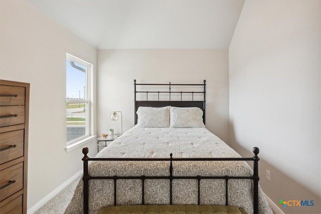 bedroom featuring carpet floors and vaulted ceiling