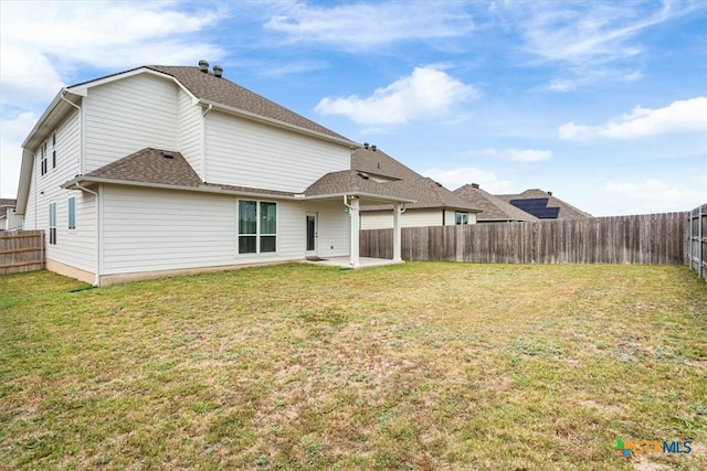 rear view of property featuring a yard and a patio area