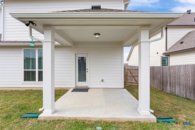 entrance to property with a patio and a yard