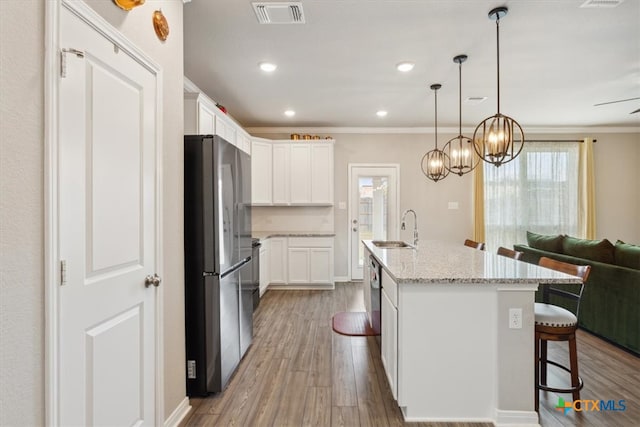 kitchen featuring wood-type flooring, white cabinetry, sink, and appliances with stainless steel finishes