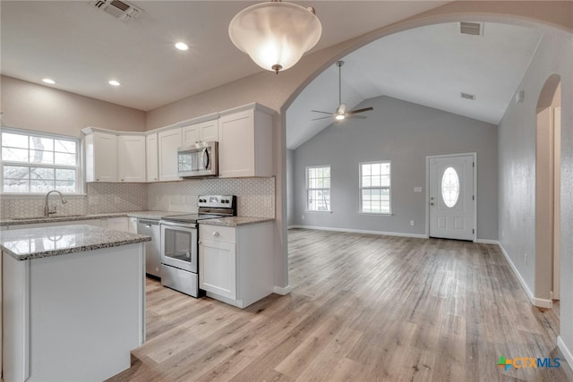 kitchen with ceiling fan, light stone countertops, tasteful backsplash, white cabinetry, and stainless steel appliances