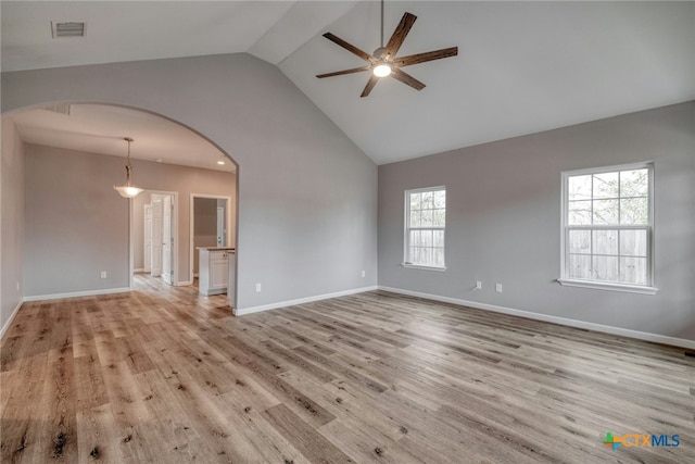 empty room with light wood-type flooring, ceiling fan, and lofted ceiling