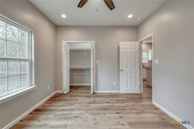 unfurnished bedroom with a closet, light hardwood / wood-style floors, and ceiling fan