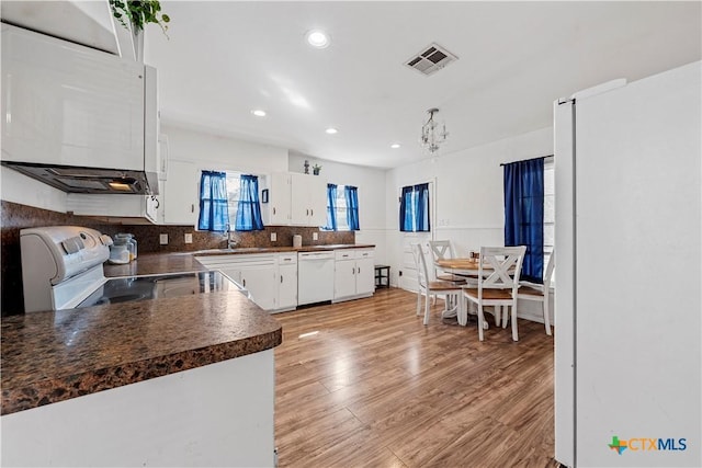 1016 E Elm St, Hillsboro, TX 76645 - kitchen with dark countertops, visible vents, white cabinets, white appliances, and a sink