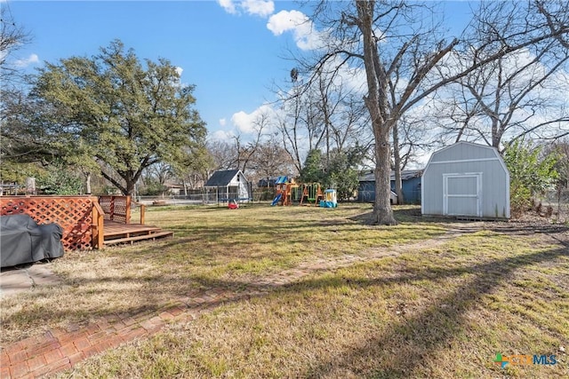 1016 E Elm St, Hillsboro, TX 76645 - view of yard with a playground, a wooden deck, a storage shed, and an outdoor structure