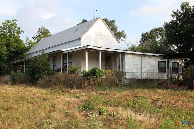 view of side of home featuring covered porch