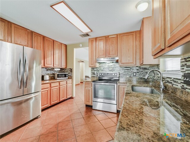 kitchen with decorative backsplash, stainless steel appliances, sink, and light tile patterned flooring