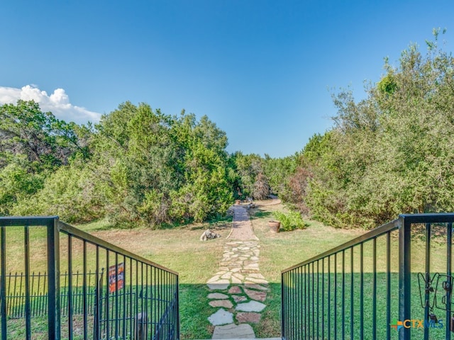 view of gate with a yard