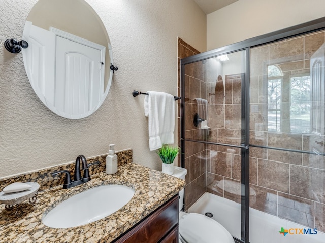 bathroom featuring walk in shower, vanity, and toilet