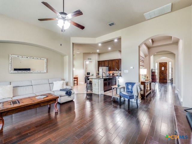 living room featuring ceiling fan, dark hardwood / wood-style floors, and sink