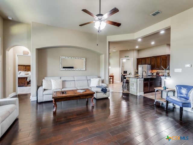 living room featuring dark hardwood / wood-style flooring, ceiling fan, and sink