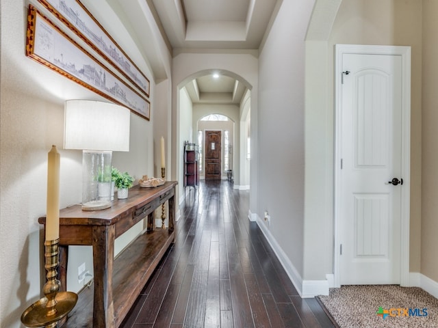 hallway featuring dark hardwood / wood-style flooring and a raised ceiling