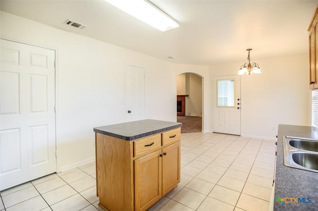 4902 Slate Ct, Killeen, TX 76542 - kitchen featuring arched walkways, light tile patterned floors, dark countertops, a chandelier, and a sink