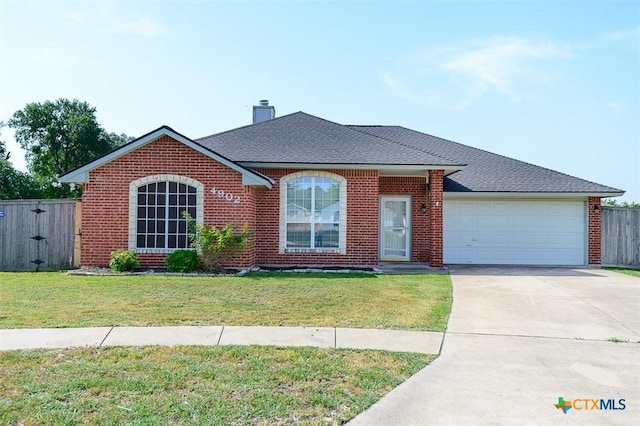 4902 Slate Ct, Killeen, TX 76542 - view of front facade with brick siding, a garage, driveway, and a chimney