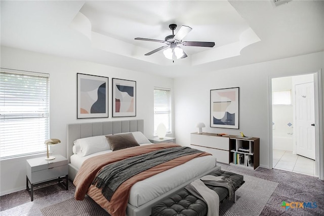 4902 Slate Ct, Killeen, TX 76542 - bedroom with a raised ceiling, light colored carpet, ensuite bathroom, a ceiling fan, and baseboards
