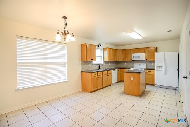 4902 Slate Ct, Killeen, TX 76542 - kitchen with white appliances, a chandelier, dark countertops, tasteful backsplash, and a center island