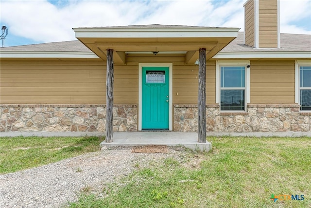 doorway to property with a lawn