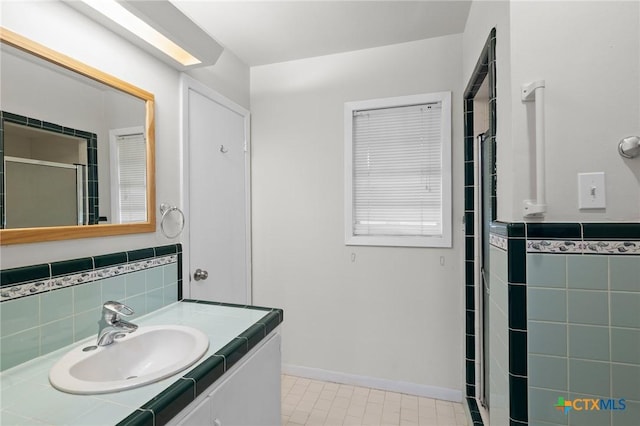 bathroom featuring vanity and tile walls