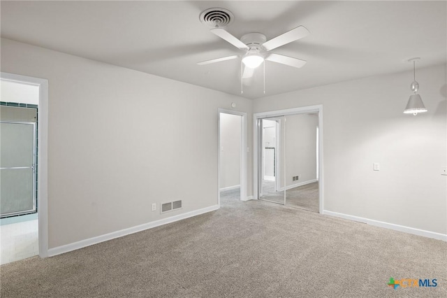 spare room with ceiling fan and light carpet