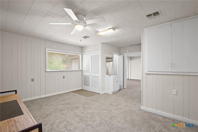 carpeted spare room with ceiling fan