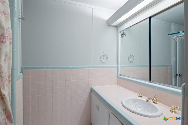 bathroom featuring vanity and tile walls