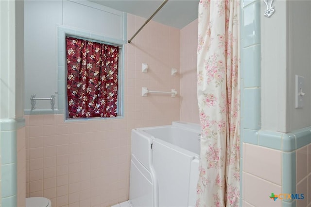 bathroom featuring tile walls